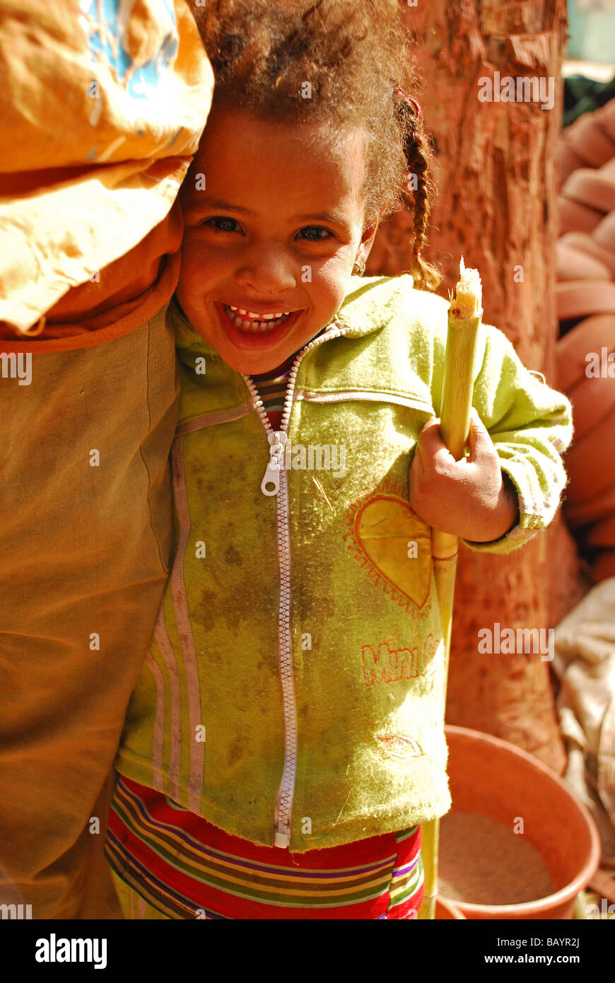 Junges Mädchen hält einen Zuckerrohr-Stiel in Dorf Stockfoto