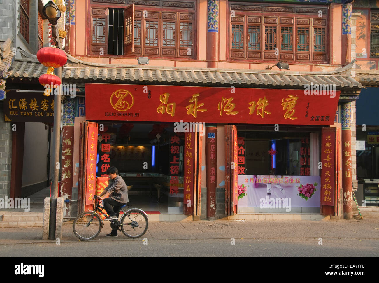 lokale fährt Fahrrad vor traditioneller Architektur in historischen Jianshui-China Stockfoto