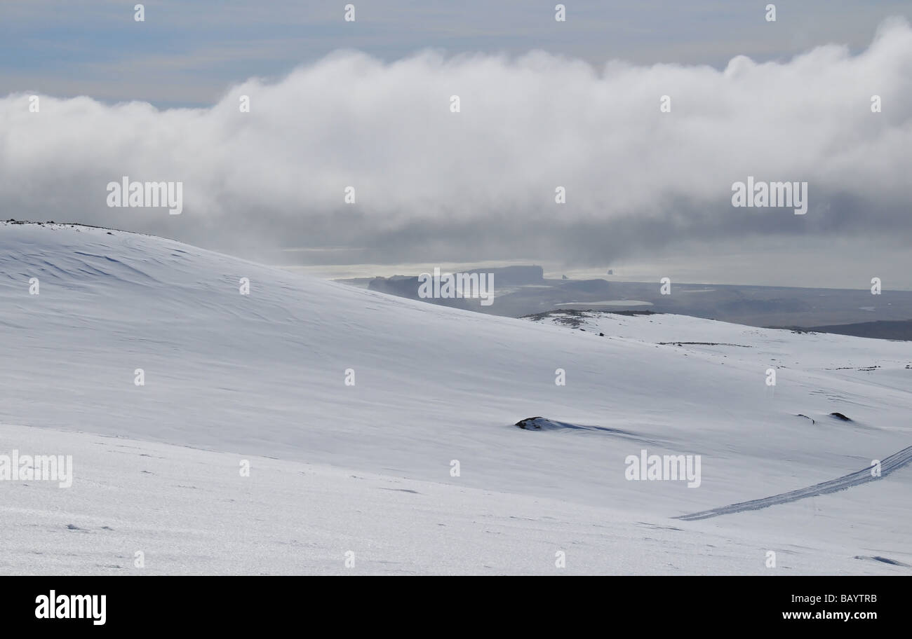 Die Dyrhólaey Landspitze, unter den Wolken am östlichen Rand des Mýrdalsjökull Eiskappe, Southern Island Stockfoto