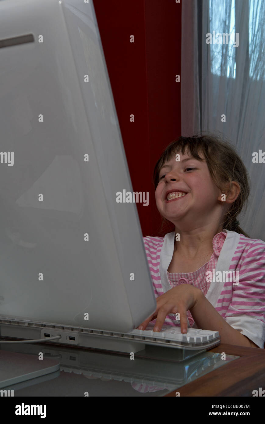 5 - Jahre altes Mädchen mit einem Apple Mac Computer. Stockfoto