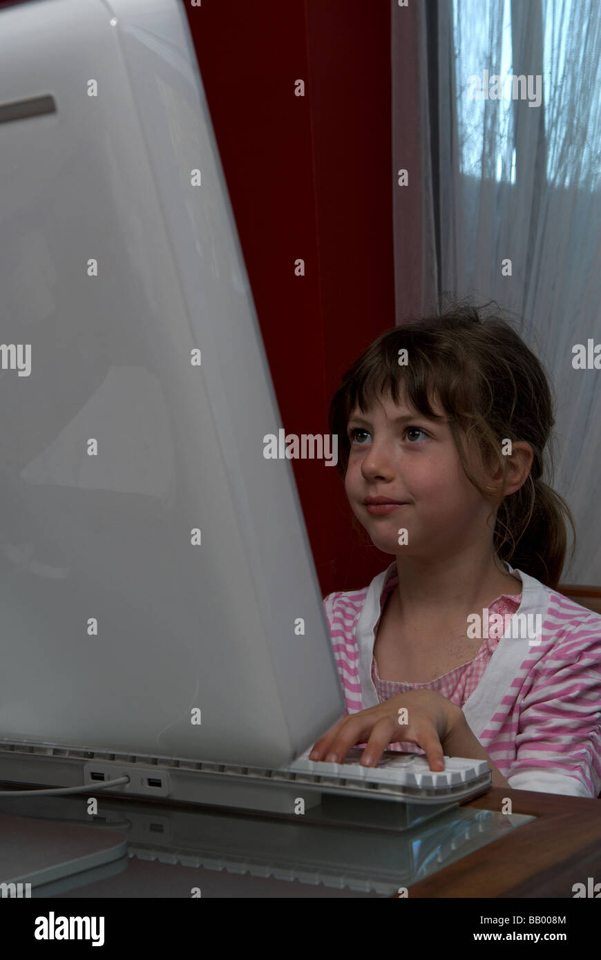 5 - Jahre altes Mädchen mit einem Apple Mac Computer. Stockfoto