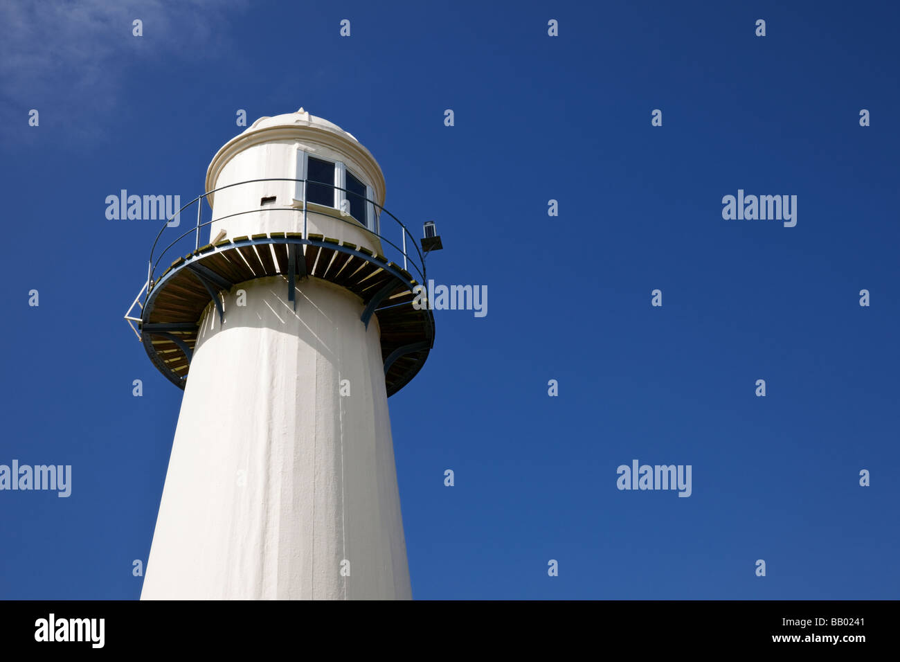 Blick auf die Spitze eines Leuchtturms vor blauem Himmel nah oben, UK Stockfoto