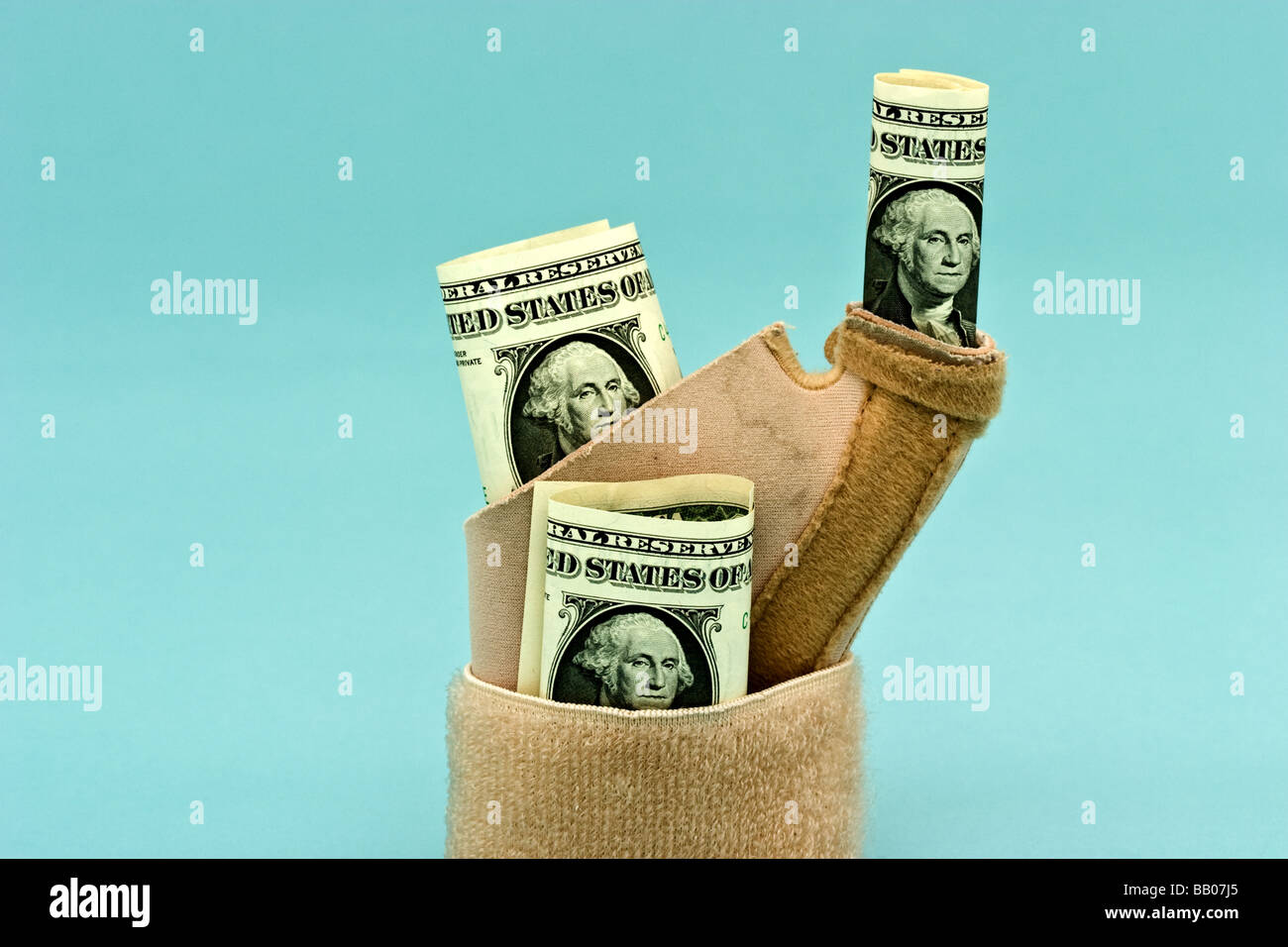 Drei amerikanische Dollarscheine ragt aus einem umlaufenden Handgelenkbandage Stockfoto