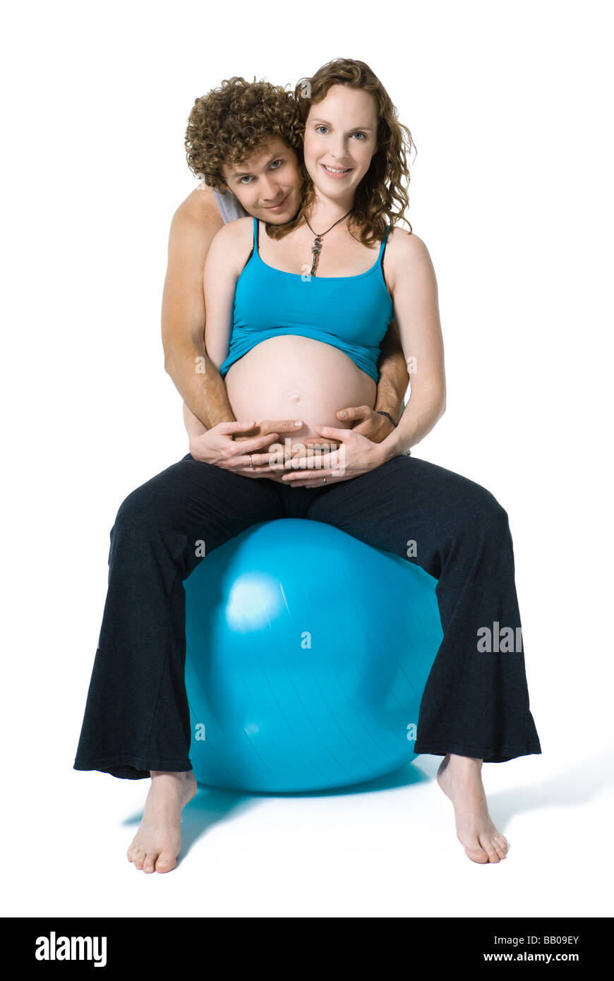 Schöne rothaarige schwangere Mädchen auf Fitball als radikalere Mann Stockfoto