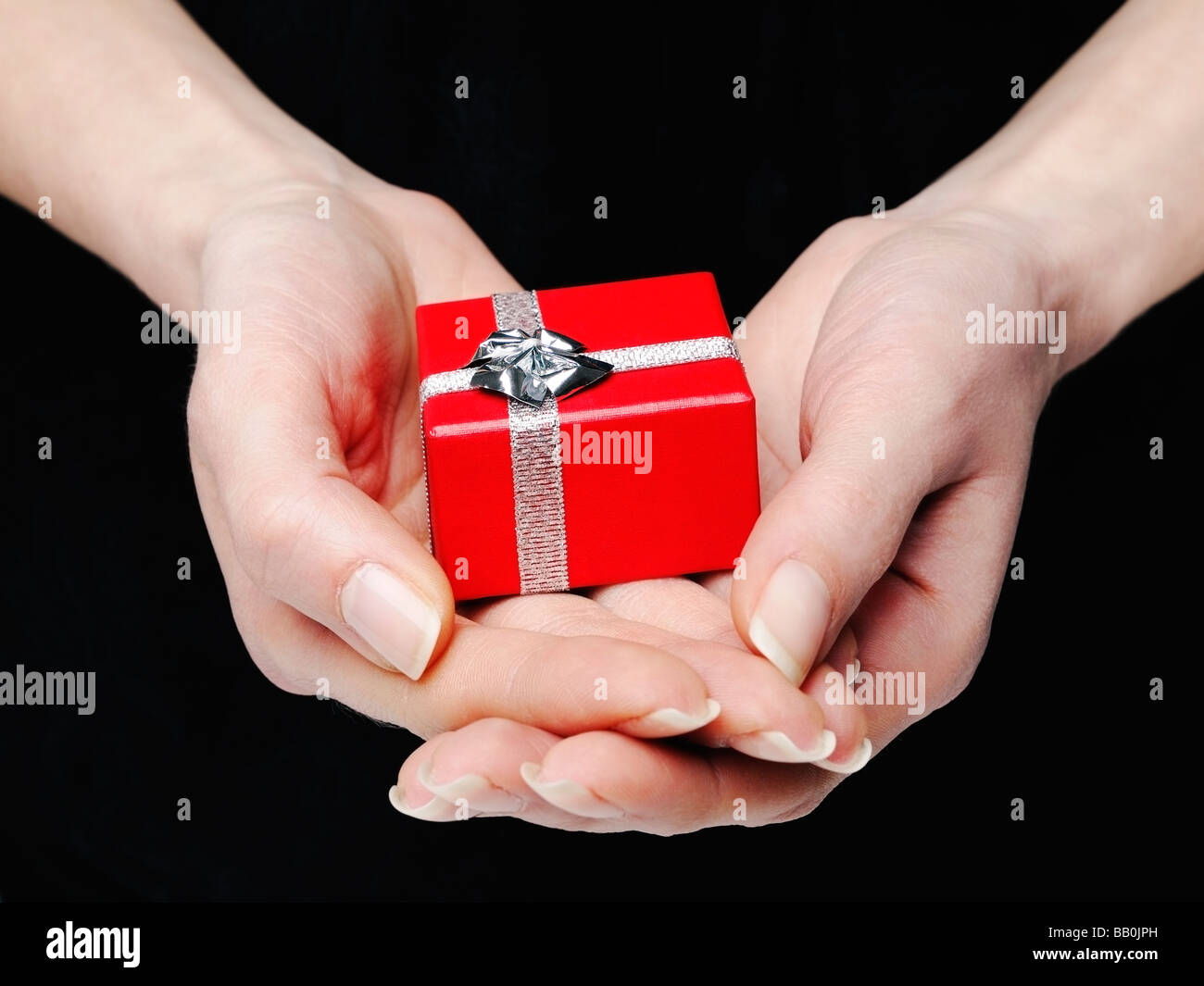 Hände halten eine roten Geschenk-Box Stockfoto