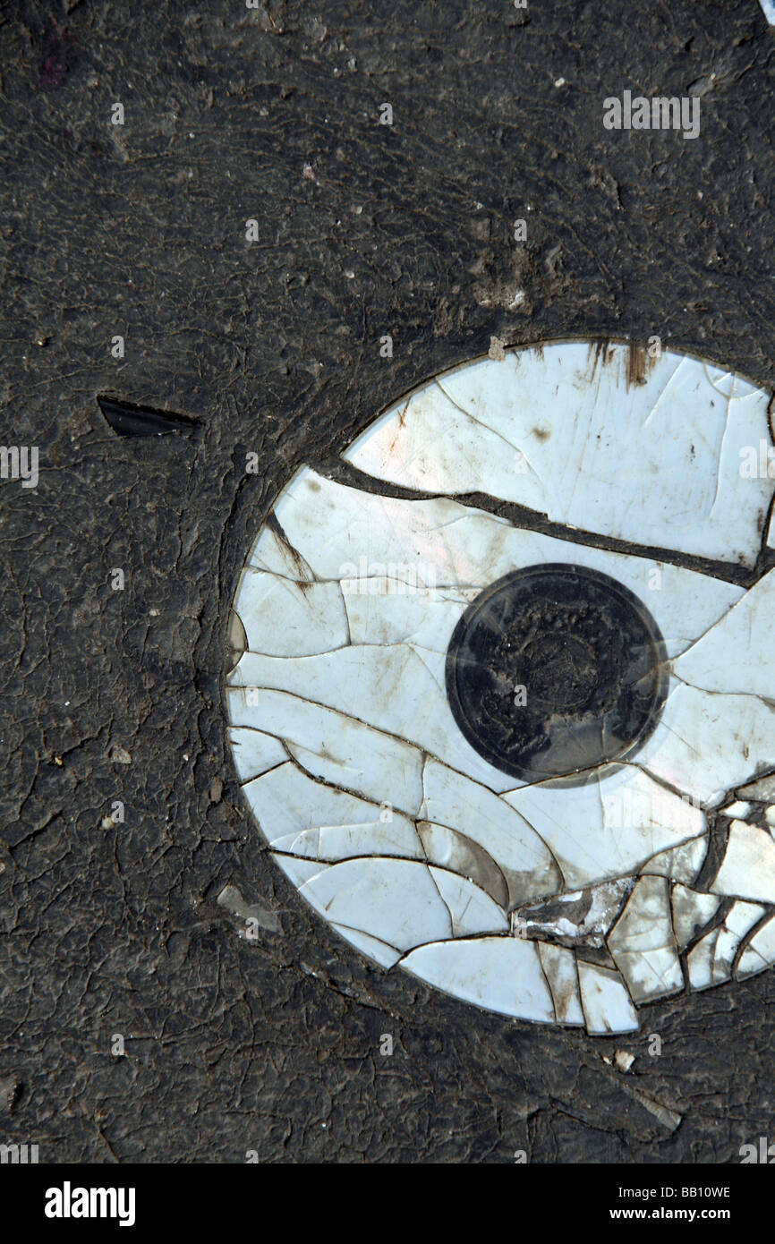 eine alte beschädigte cd Compcat Disk auf Fahrbahn Stockfoto