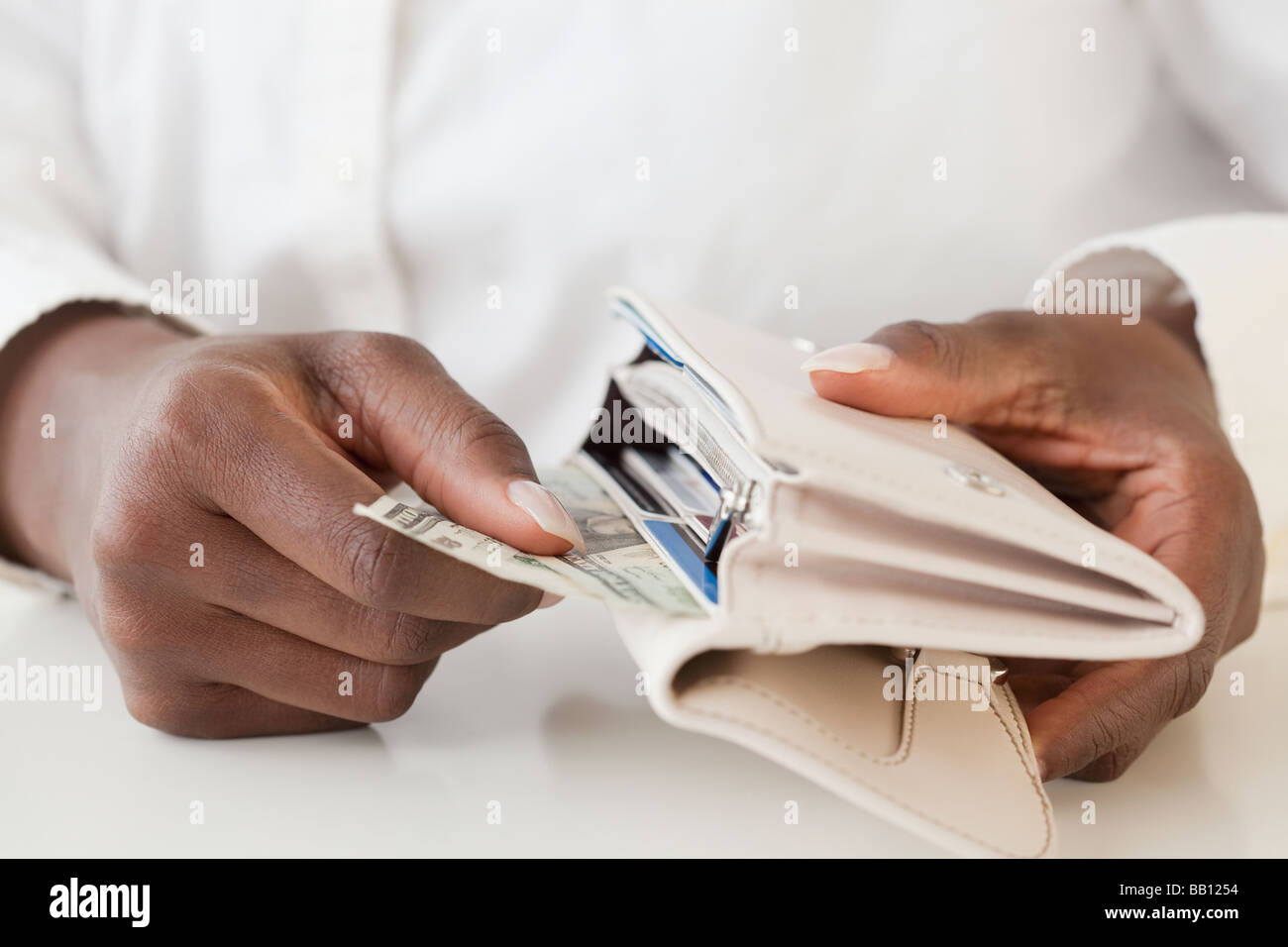 Afrikanische Frau, die Geld aus der Brieftasche Stockfoto