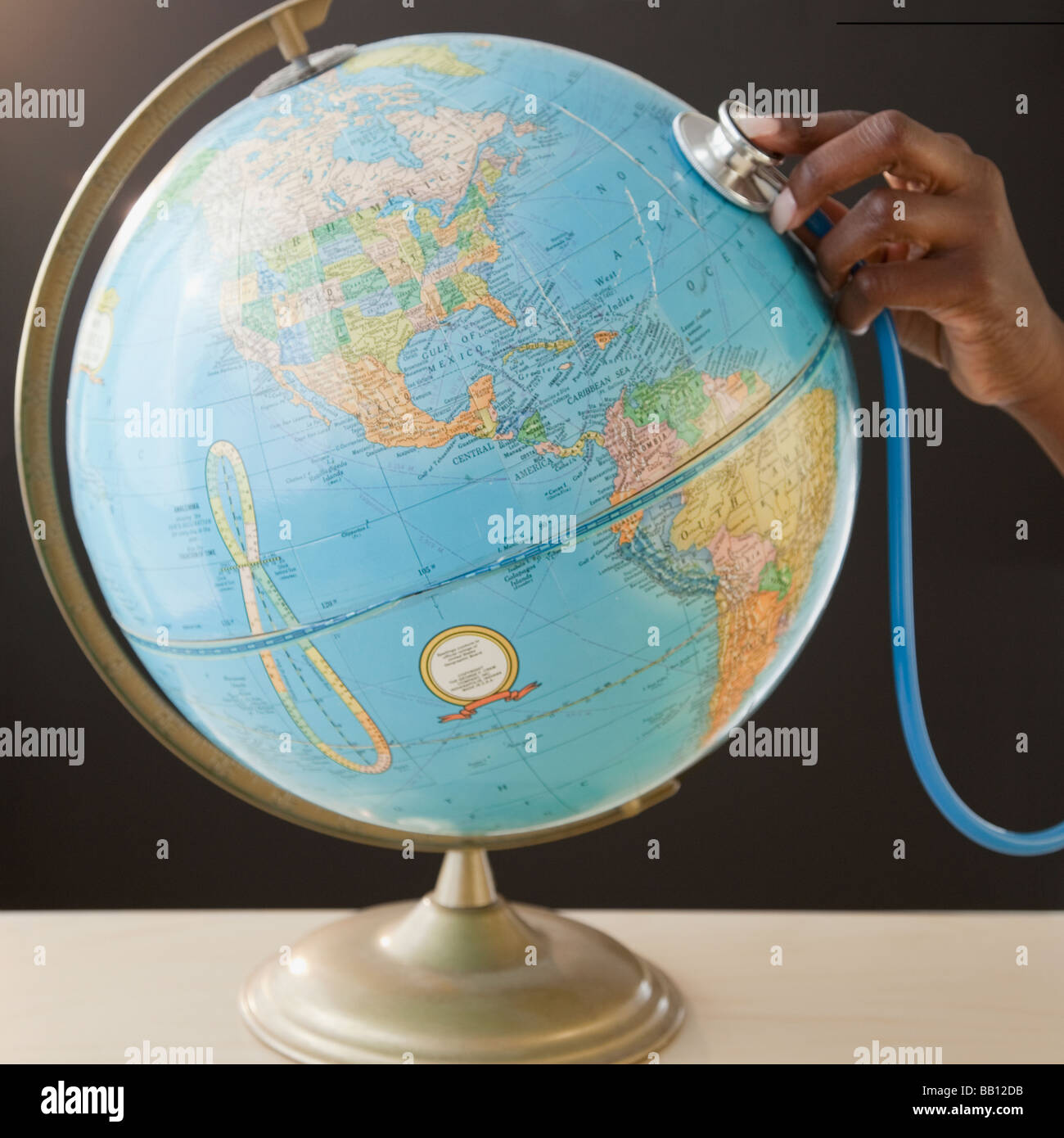 Afrikanerin mit Stethoskop auf Globus Stockfoto