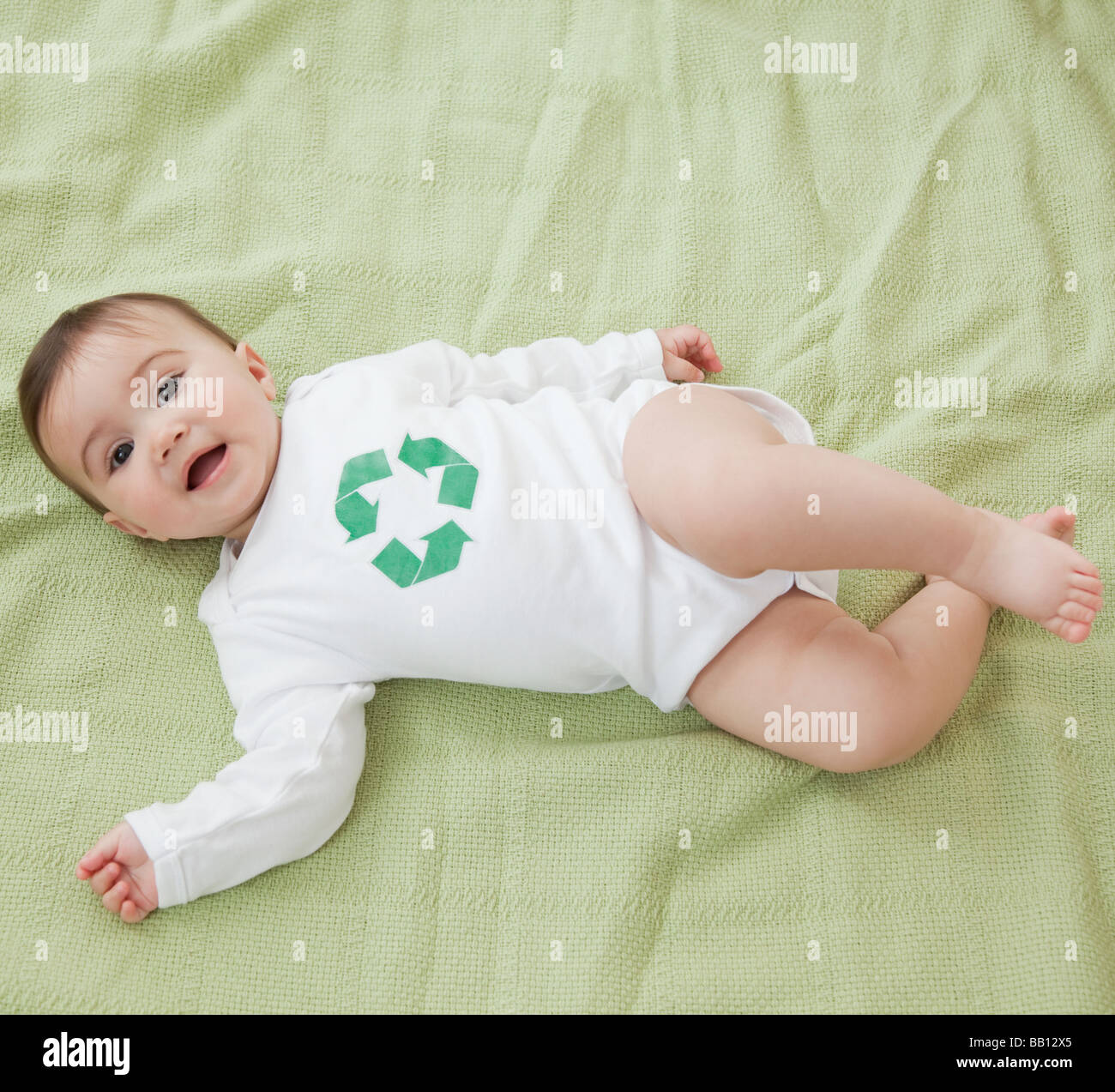 Gemischte Rassen Babymädchen mit recycling-Zeichen auf t-Shirt Stockfoto