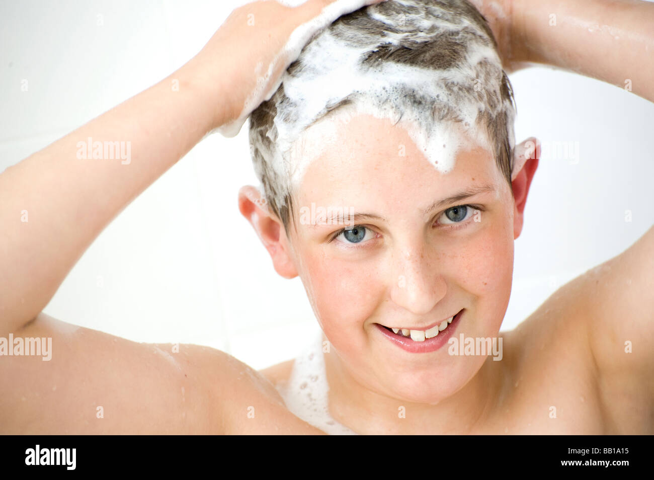 Kleiner Junge seine Haarwäsche mit Shampoo in der Dusche Stockfoto