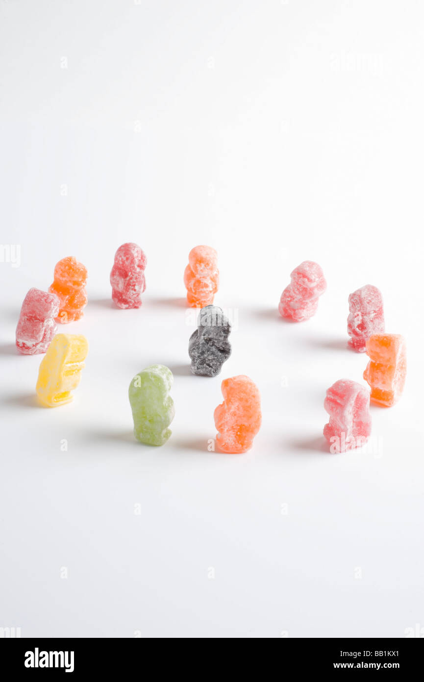 Einzelne schwarze Jelly Baby von 10 anderen in einem Kreis umgeben. Stockfoto