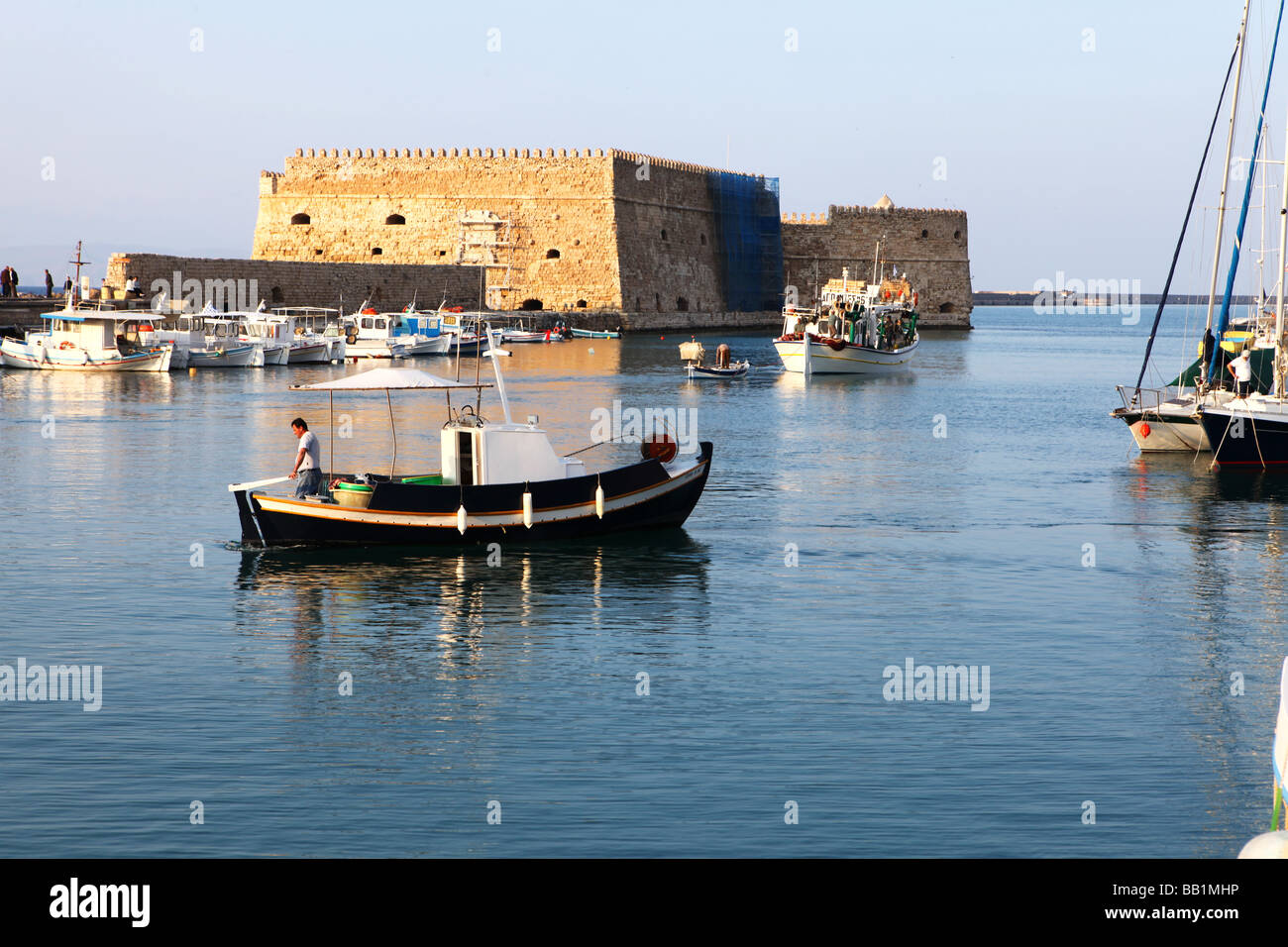 Angelboote/Fischerboote aus Heraklion Hafen Kreta Griechenland am frühen Abend mit der venezianischen Burg im Hintergrund Stockfoto