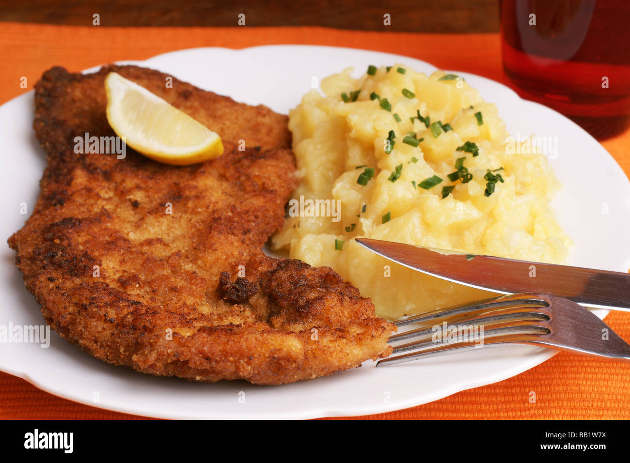 Wiener Schnitzel mit Kartoffelsalat, garniert mit gehackten Schnittlauch Stockfoto