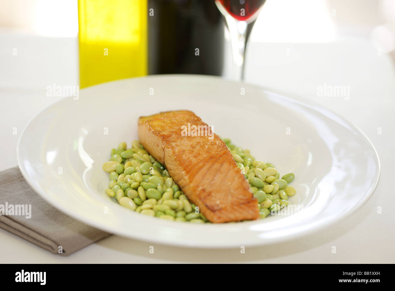 Frisch gegrilltes Lachsfilet oder Steak mit Edamame Bohnen und ein Glas Rotwein mit Keine Personen Stockfoto