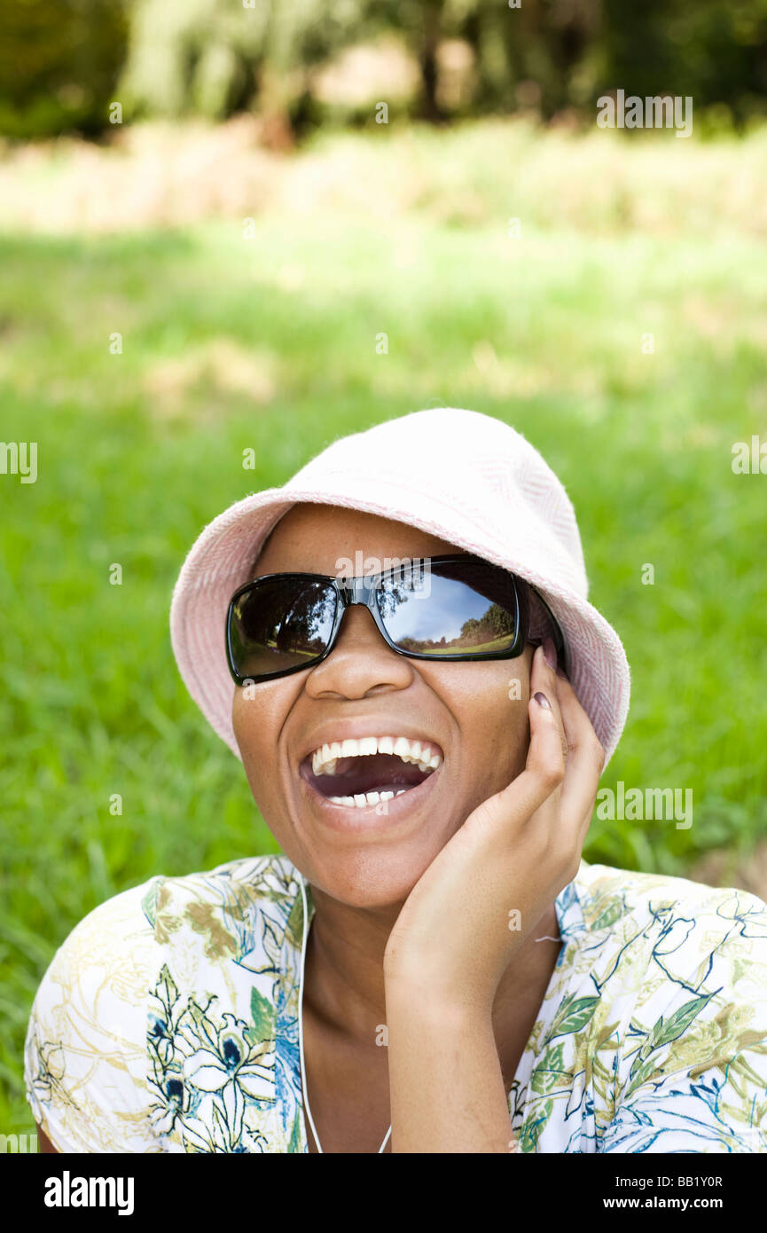 Frau, zuhören, einen tragbaren Musik-Player in einem Park, Johannesburg, Provinz Gauteng, Südafrika Stockfoto
