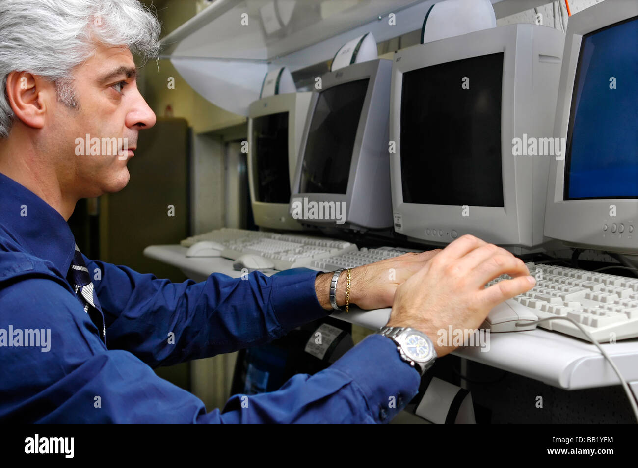 Techniker mit Blick auf einem Computerbildschirm und Dateneingabe Stockfoto