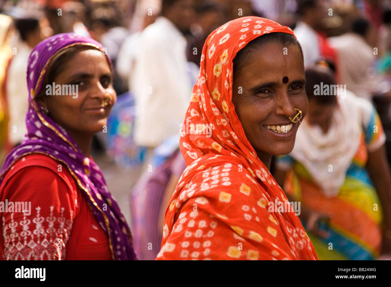 Zwei bunt gekleidete Frauen stehen zusammen auf einem Markt in der Altstadt von Ahmedabad, Gujarat Stockfoto