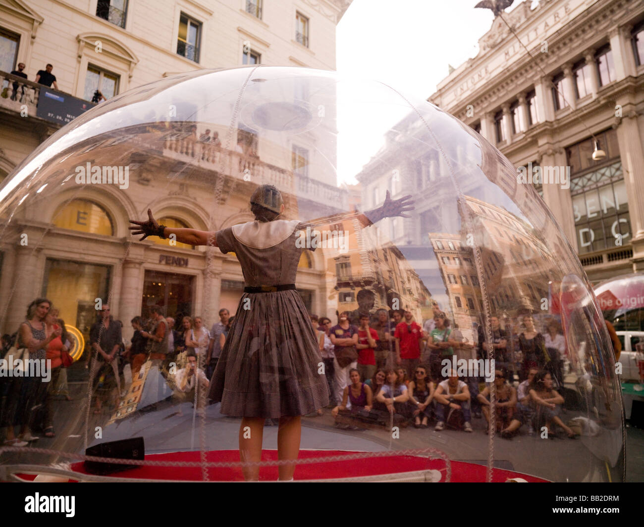Frau, innen transparente Glaskugel und Publikum beobachten ihre Leistung; Rom, Italien Stockfoto