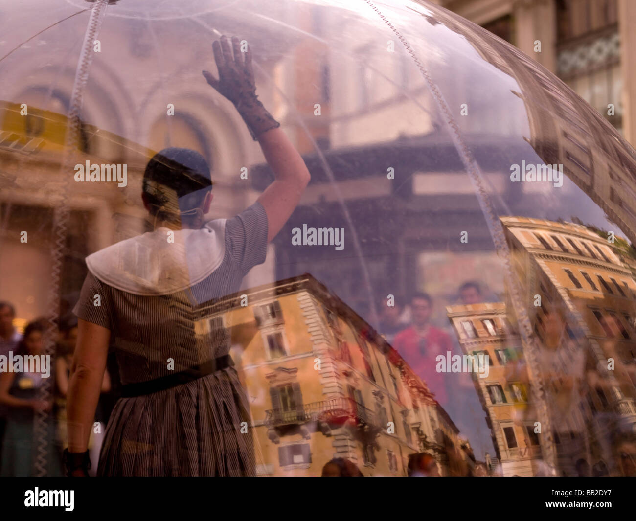 Frau, innen transparente Glaskugel und Publikum beobachten ihre Leistung; Rom, Italien Stockfoto