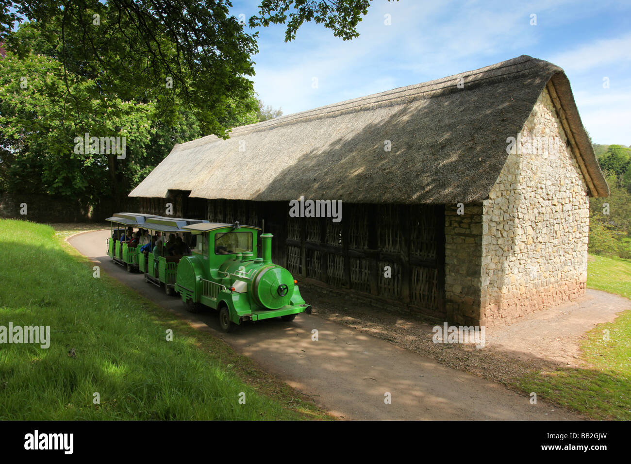 Touristischen Personenzug fährt vorbei an einem alten historischen rekonstruierten Bauernhaus an St Fagans nationales Geschichte Museum of Wales Stockfoto