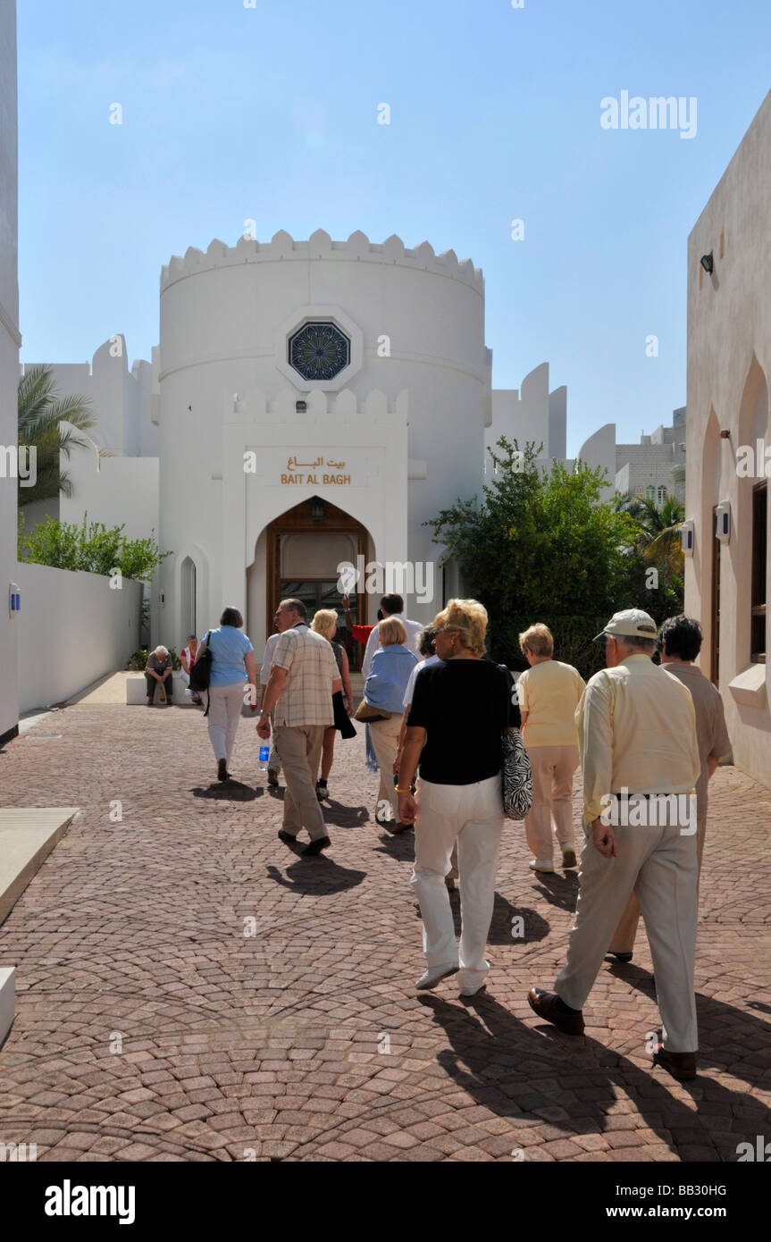 Maskat Oman Tourleiter und Rückansicht erwachsener Touristen vom Kreuzfahrtschiff auf Busausflug am Haupteingang des Bait Al Zubair Waffenmuseums Asia Stockfoto