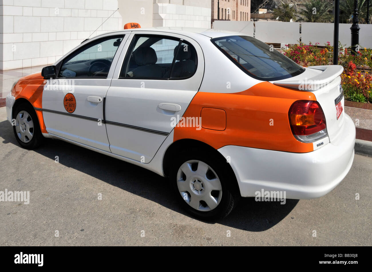 Seite & Rückseite offizielle farbcodierte orange & weiß Taxi ausgewählte Karosserieteile in Farbe Muscat Oman am Golf von Oman Naher Osten ausgewählt Stockfoto