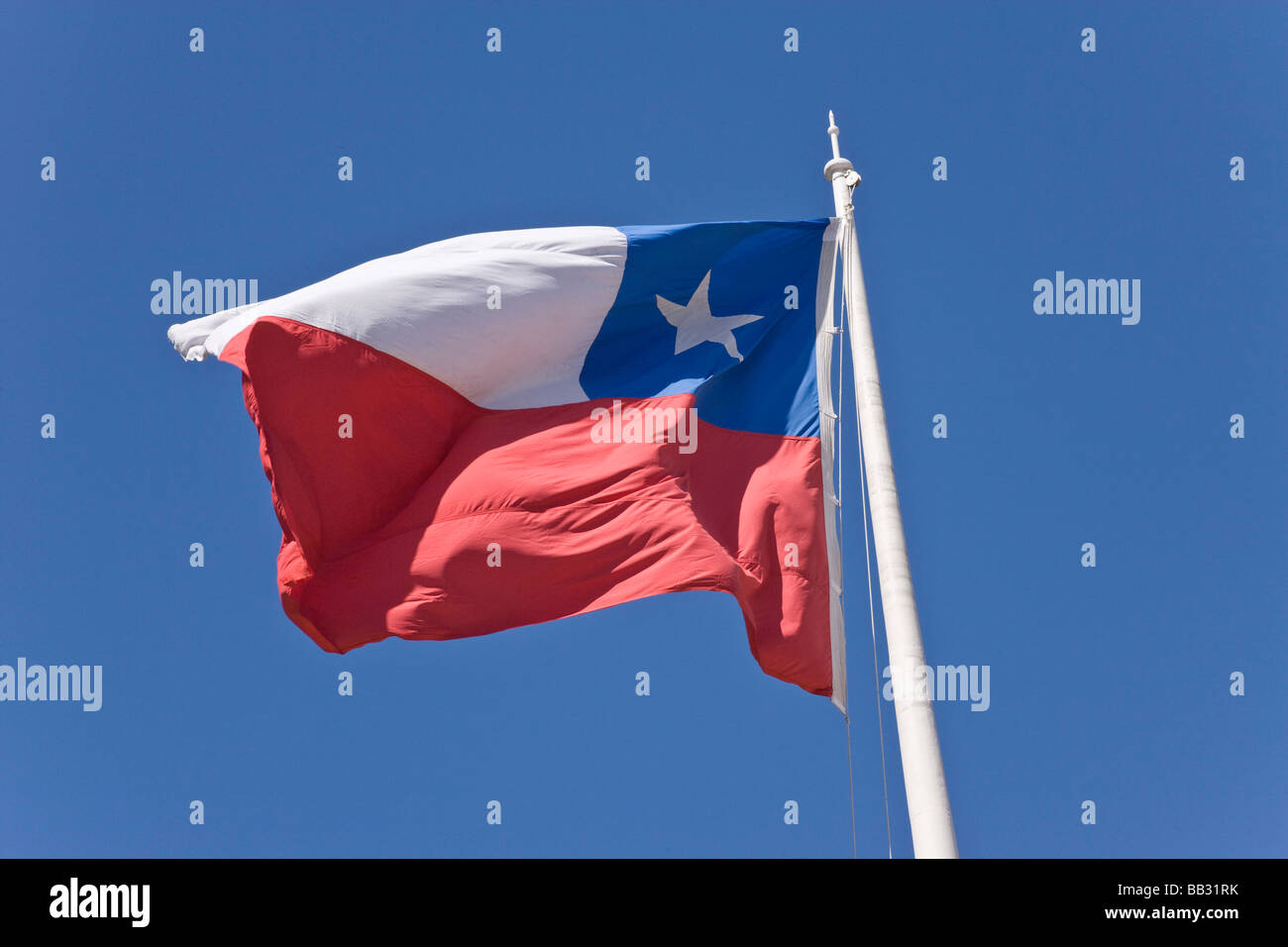 Chile, Patagonien, Punta Arenas. Chilenische Flagge Wellen gegen blauen Himmel. Stockfoto