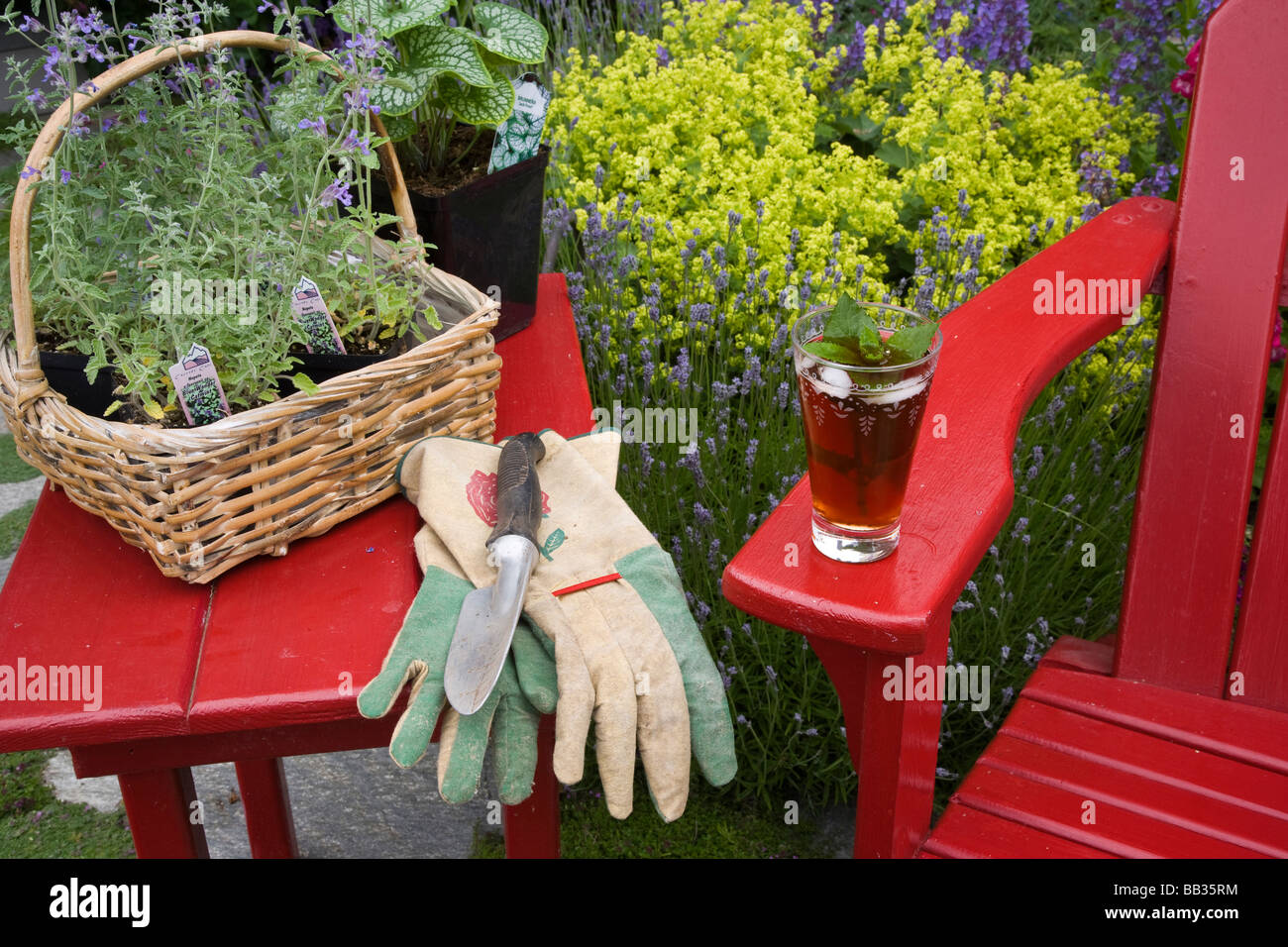 Eistee ruht auf roten Stuhl bei der Gartenarbeit. Stockfoto