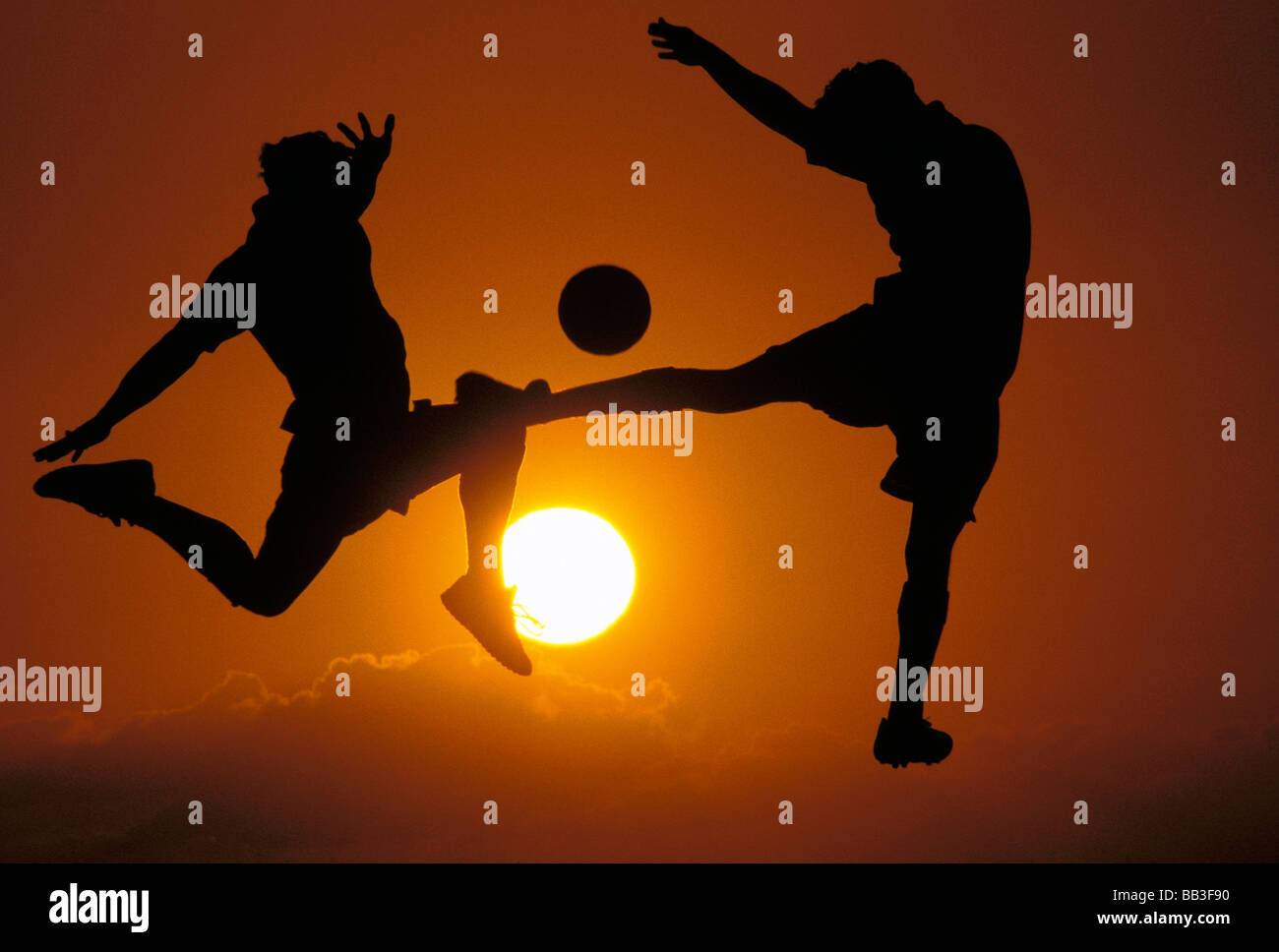 USA, Hawaii. Männer spielen Fußball in der Abenddämmerung Stockfoto