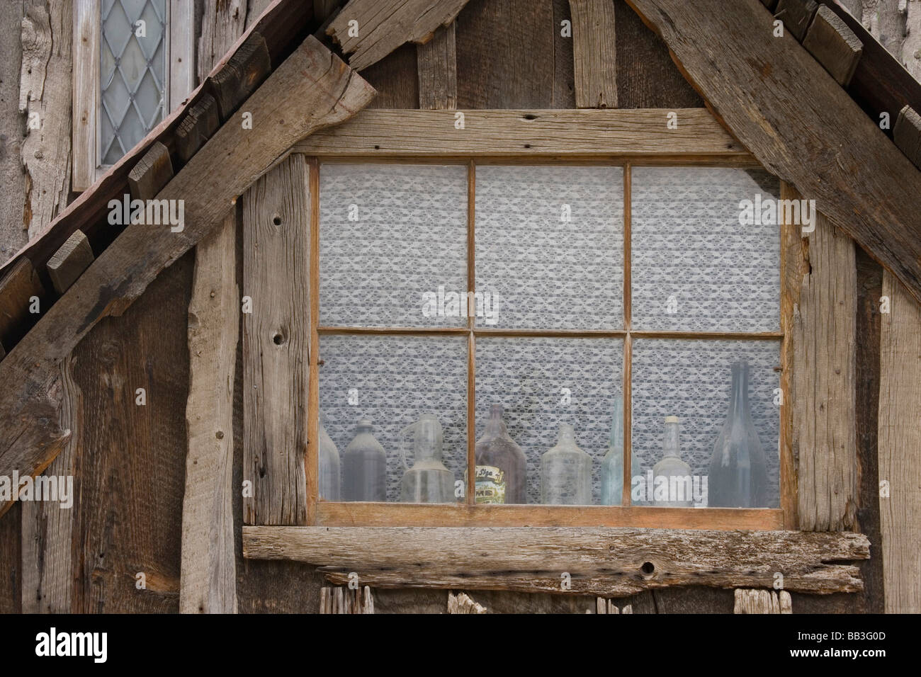 USA, Idaho, Idaho City. Altbauwohnung mit staubigen Flaschen im Fenster. Stockfoto