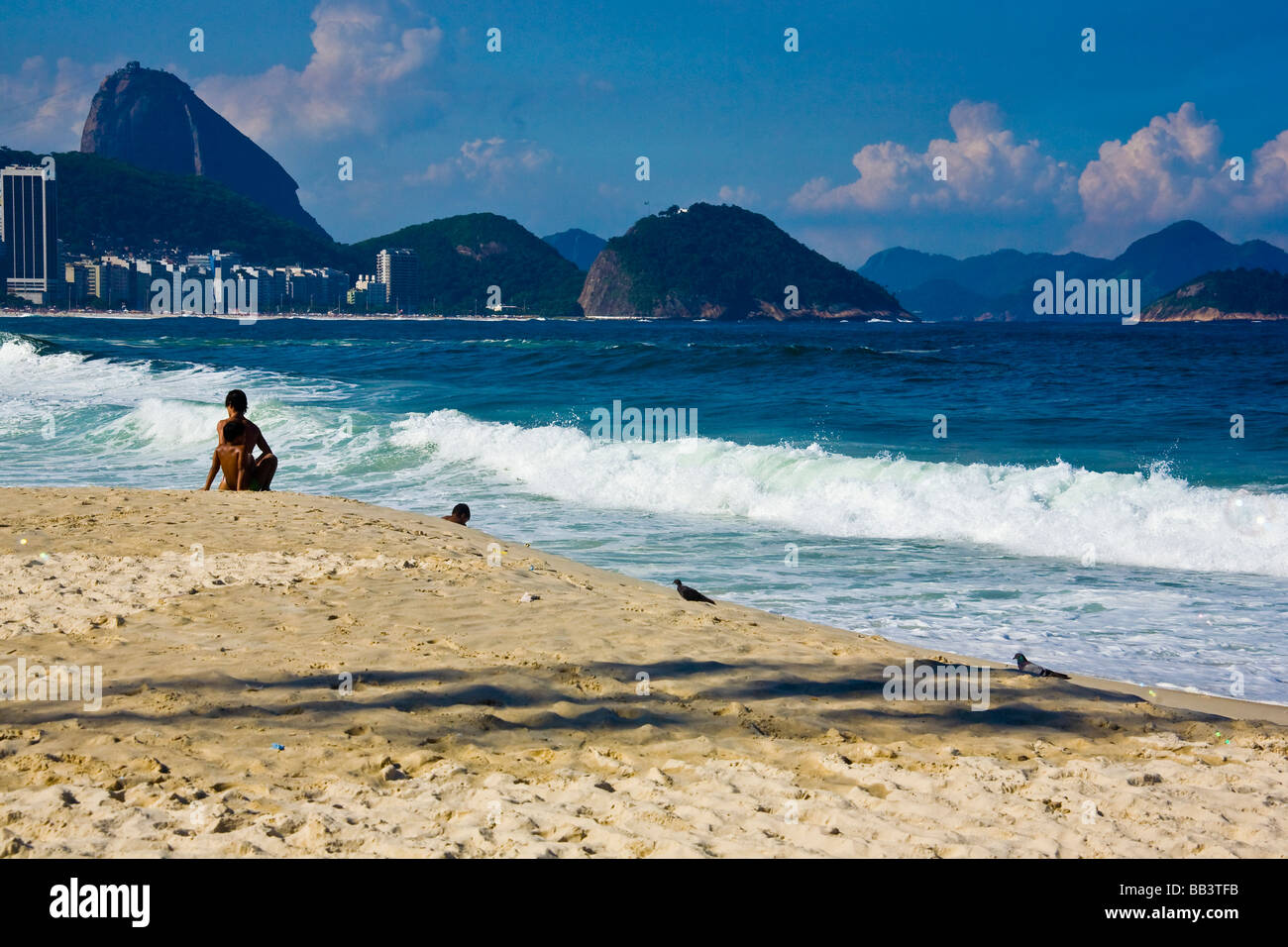 Kinder genießen die Sonne am Strand der Copacabana, Rio De Janeiro, mit Sugraloaf Berg und Leme
