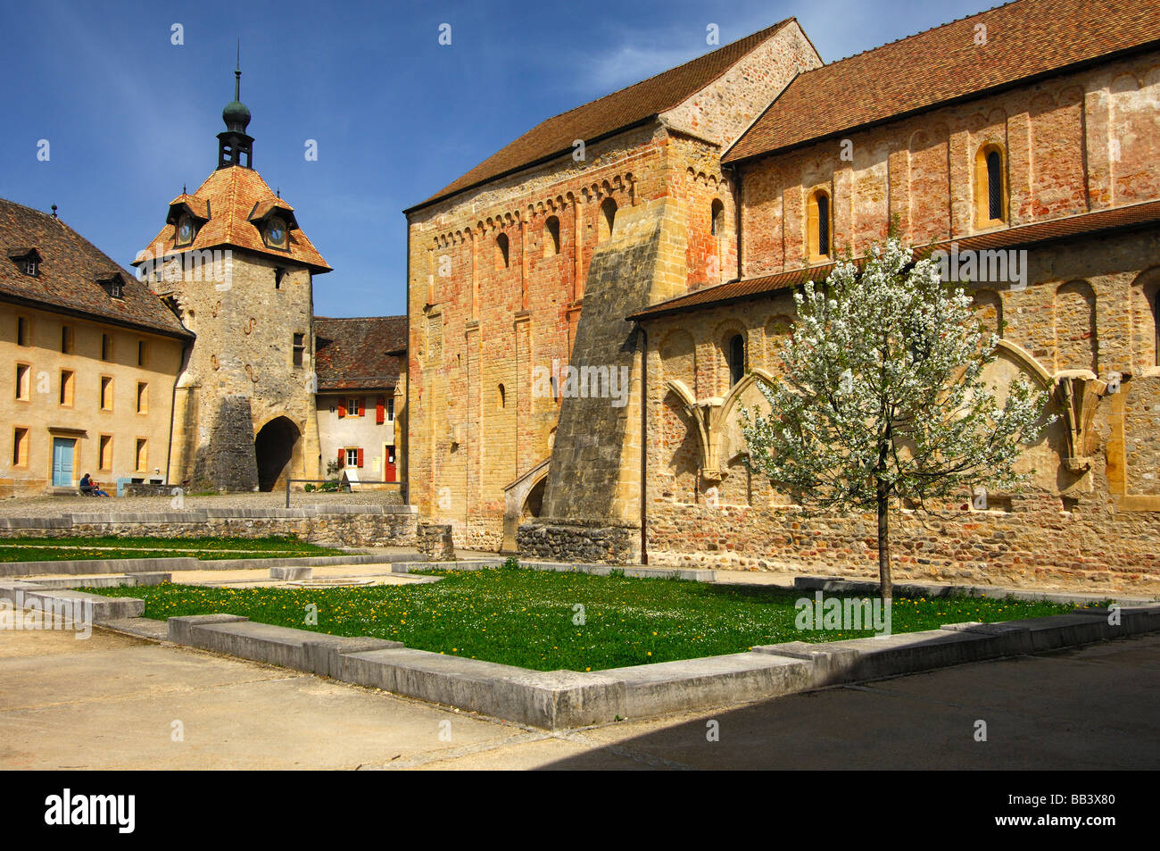 Clock Tower und Schiff der Collegiaet Kirche in romanischen Abtei von Romainmotier, Kanton Waadt, Schweiz Stockfoto