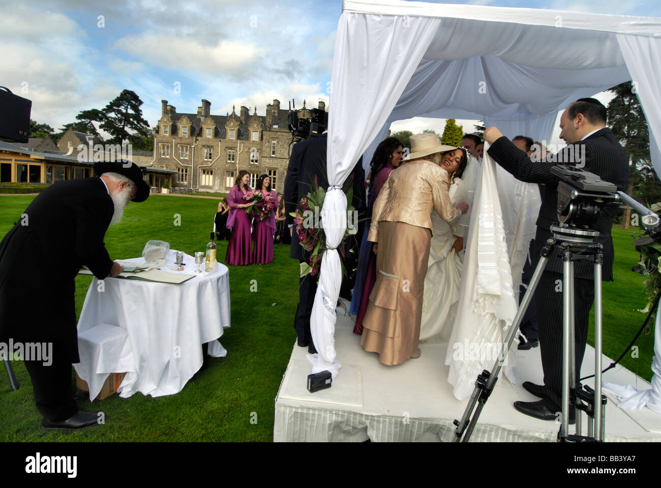 Braut küssen Schwiegermutter bei jüdischen Open air Hochzeit in Nord-London Stockfoto