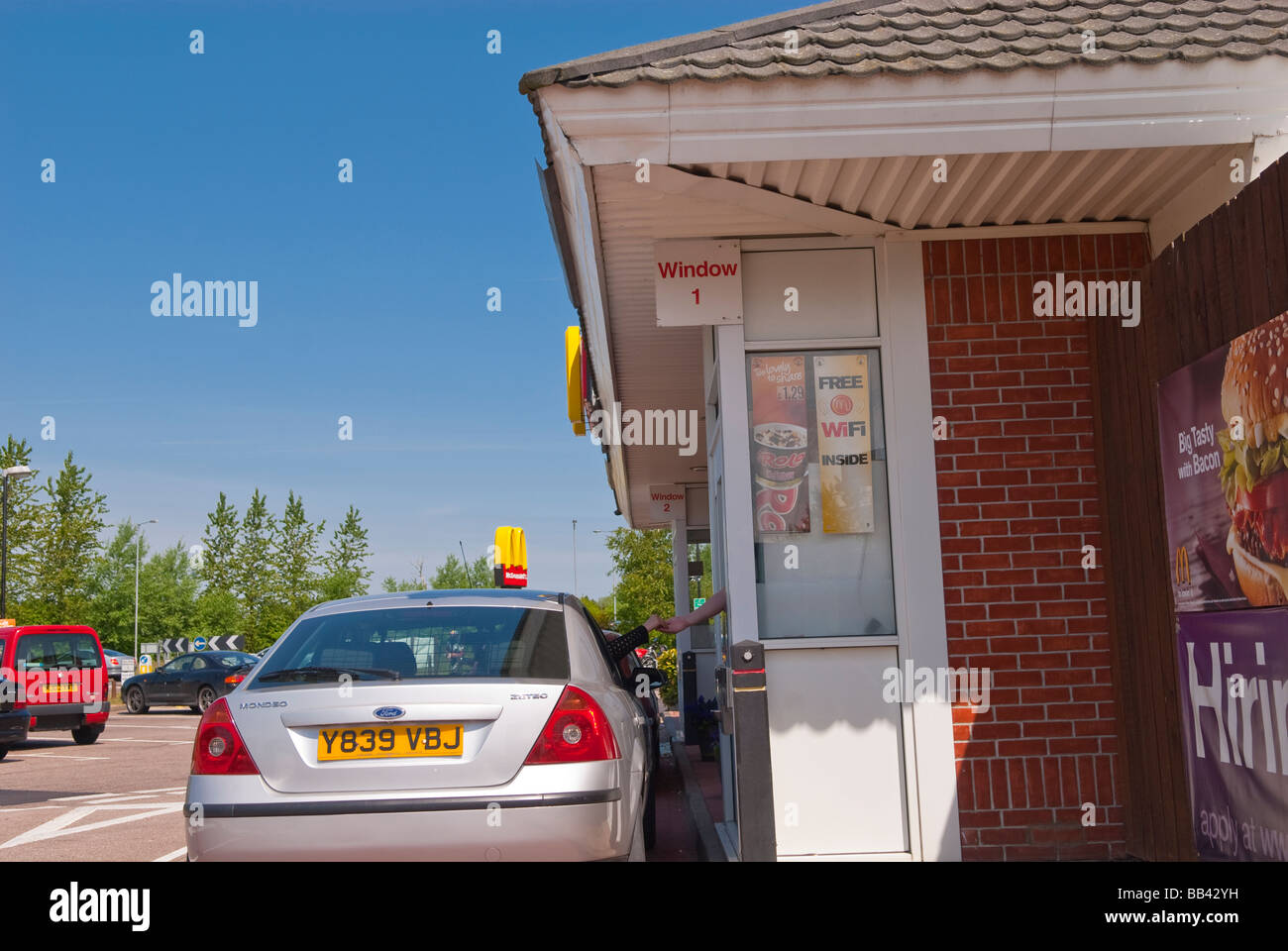Autos Queing oben in einem Mcdonalds-Restaurant fahren, durch (über) um ihre Fast-Food-Burger im Vereinigten Königreich Stockfoto