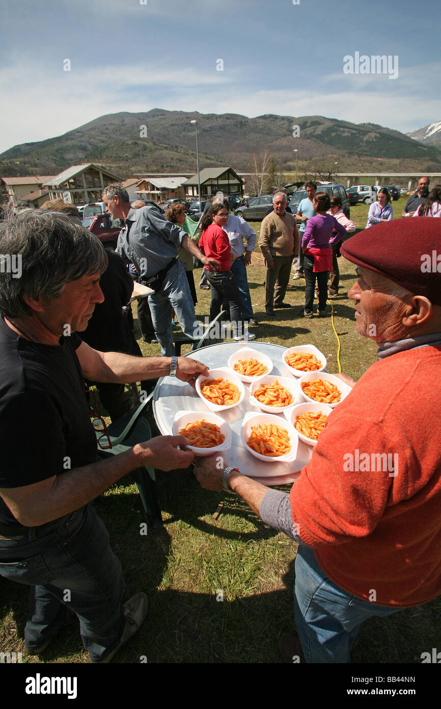 Freiwillige verteilen Pasta zu einer öffentlichen Futterstelle Assergi Arbruzzo nach dem Erdbeben vom 6. April Italty Stockfoto