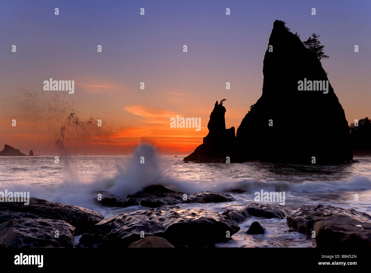 USA, Washington, Olympic Nationalpark. Sonnenuntergang Silhouetten und plätschernden Wellen am Rialto Strand. Stockfoto