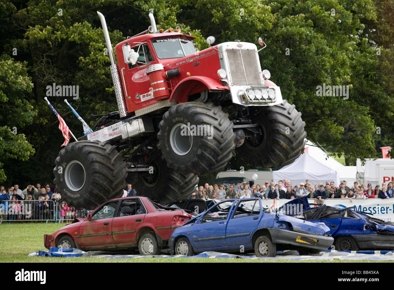 Monster trucks vernichtende alte Autos bei einer Farm Show, Gloucestershire, UK Stockfoto