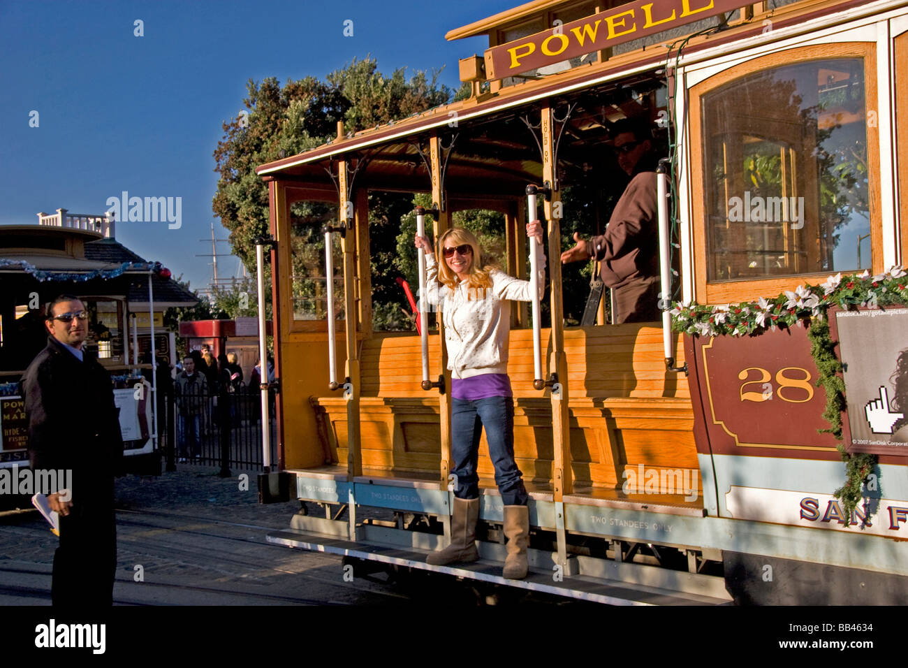 Hübsche blonde Frauen Sonnenbrillen spielt auf einer Seilbahn während Friedel Klussmann Memorial Turnaround der Dirigent anschaut, auf Stockfoto