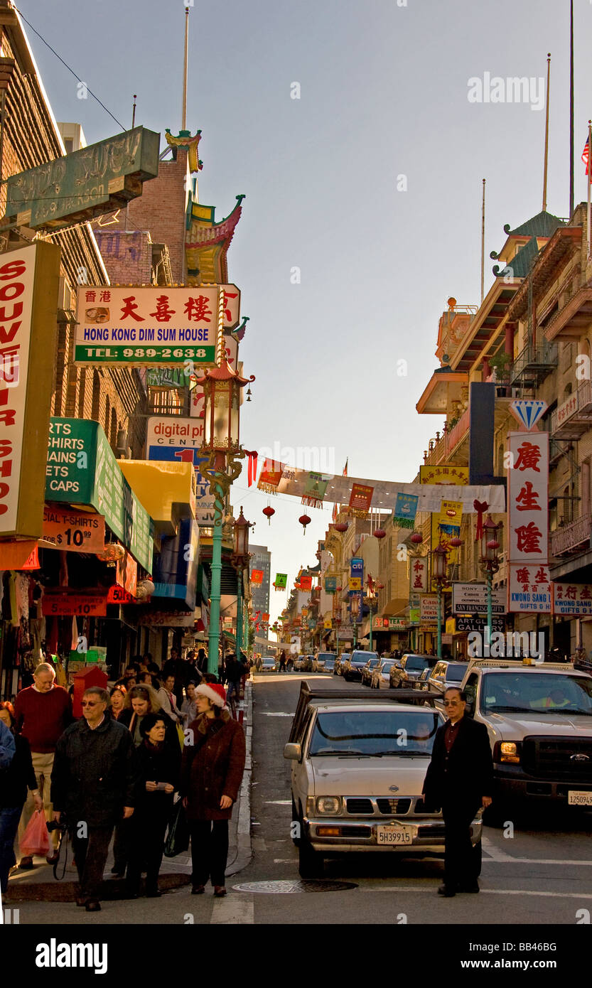 Eine beschäftigt Straßenszene in San Francisco Chinatown, mit aktiven Menschen und Autos und typische chinesische Zeichen und Dekorationen. Stockfoto