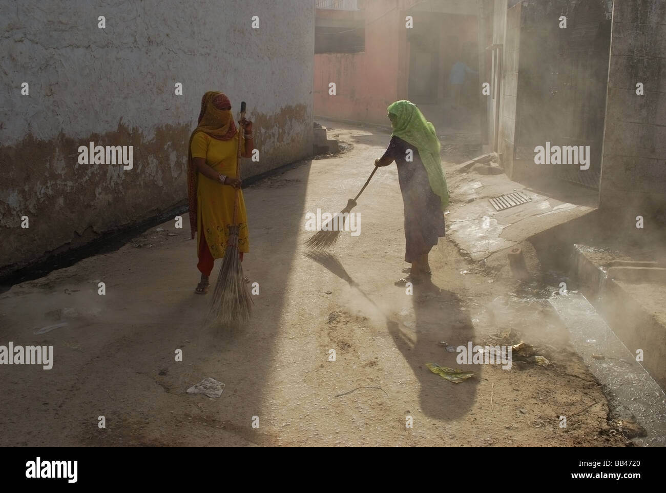 Zwei Frauen Bürsten Staub auf der Straße von Delhi Stockfoto