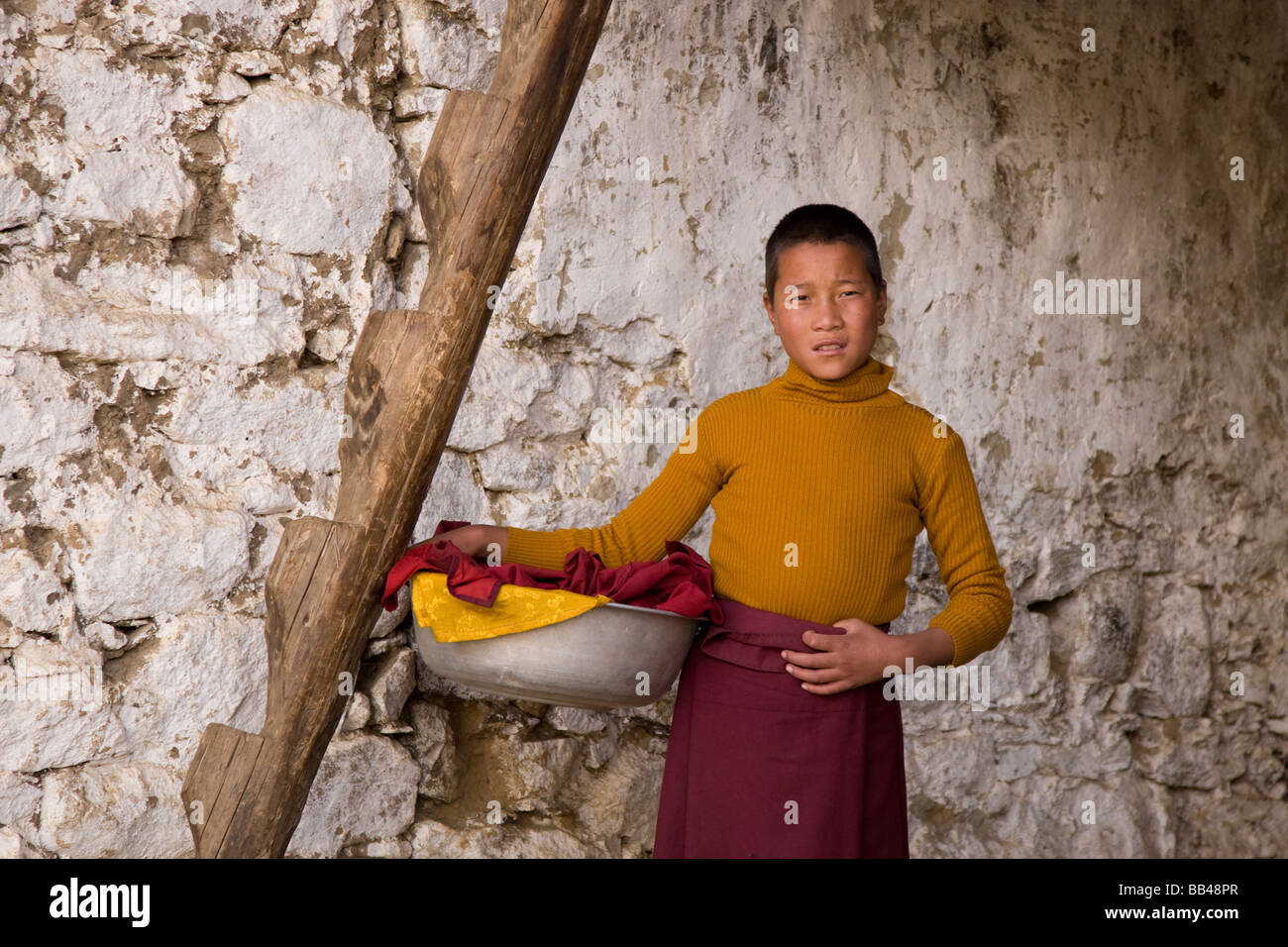 Ein Mönch hält eine Waschen bin in Lingshi, Bhutan. Stockfoto