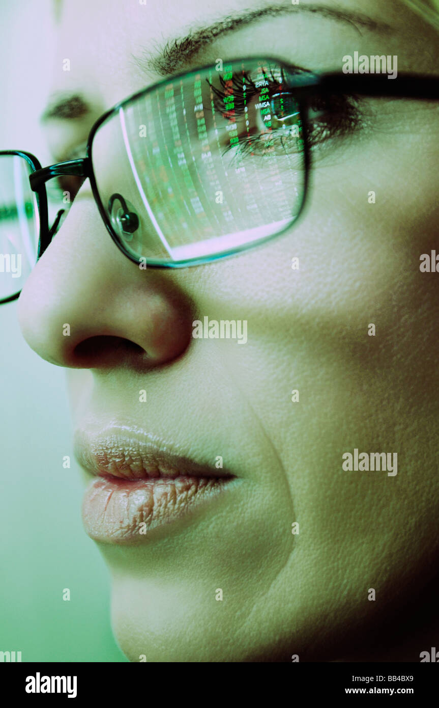 Frauen Gesicht mit Brille spiegelt ein Computer-Display der Börsenkurse Stockfoto