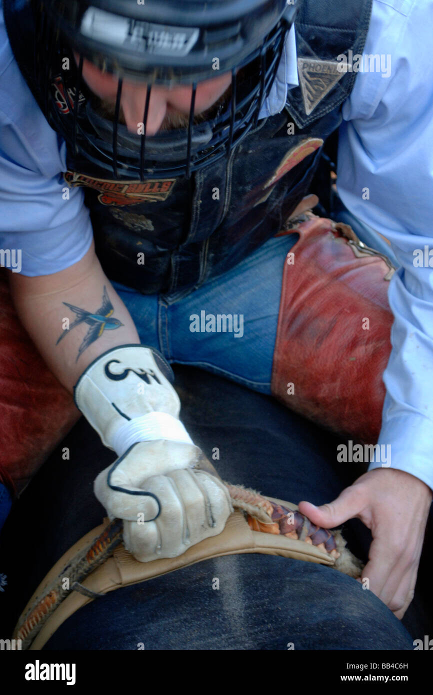 Cowboy, Bull Rider mit Schutzhelm mit Gesichtsmaske ist selbst zu komponieren und immer sicheren Halt, als er bereitet sich auf eine Fahrt. Stockfoto