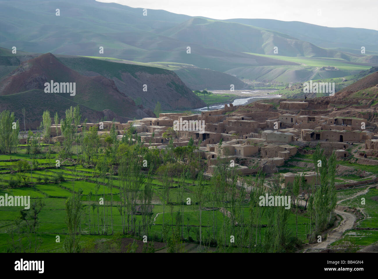 Schlamm Häuser Cluster über grüne Felder in das Dorf von Dera Jawal, entlang eines Flusses am Fuße des Band-e Baba Bereich, Herat P Stockfoto