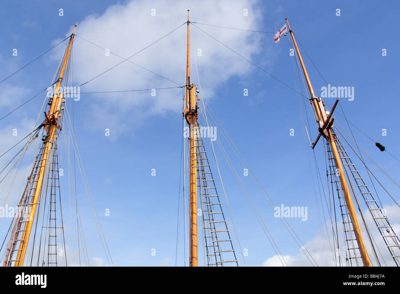 Drei hölzerne Masten auf restaurierten historischen Handel Schoner mit rigging und Flagge von St. Georg. Stockfoto