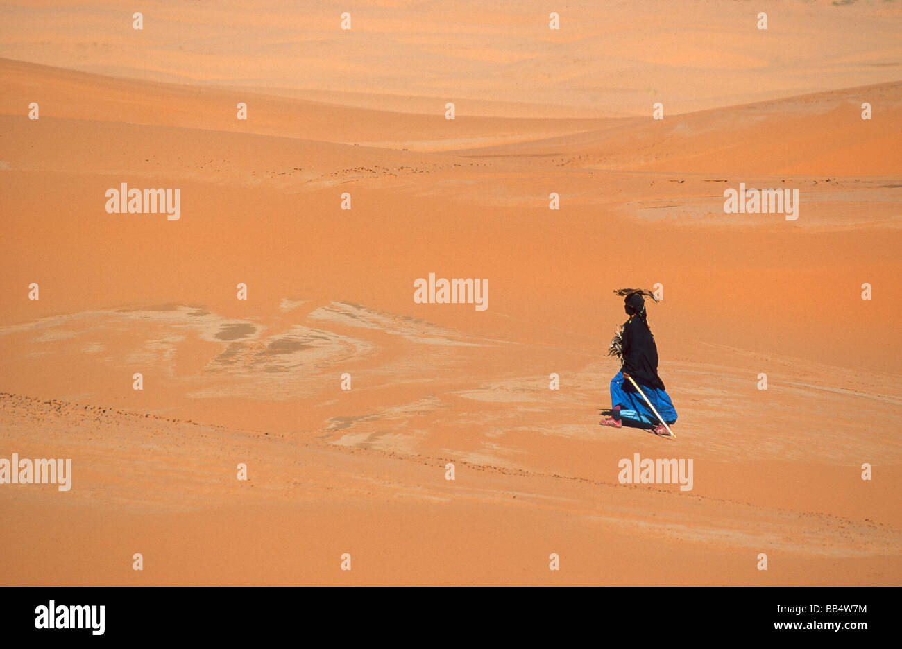 Beduin Frau zu Fuß durch die Dünen des Erg Chebbi, Westsahara, Marokko Stockfoto