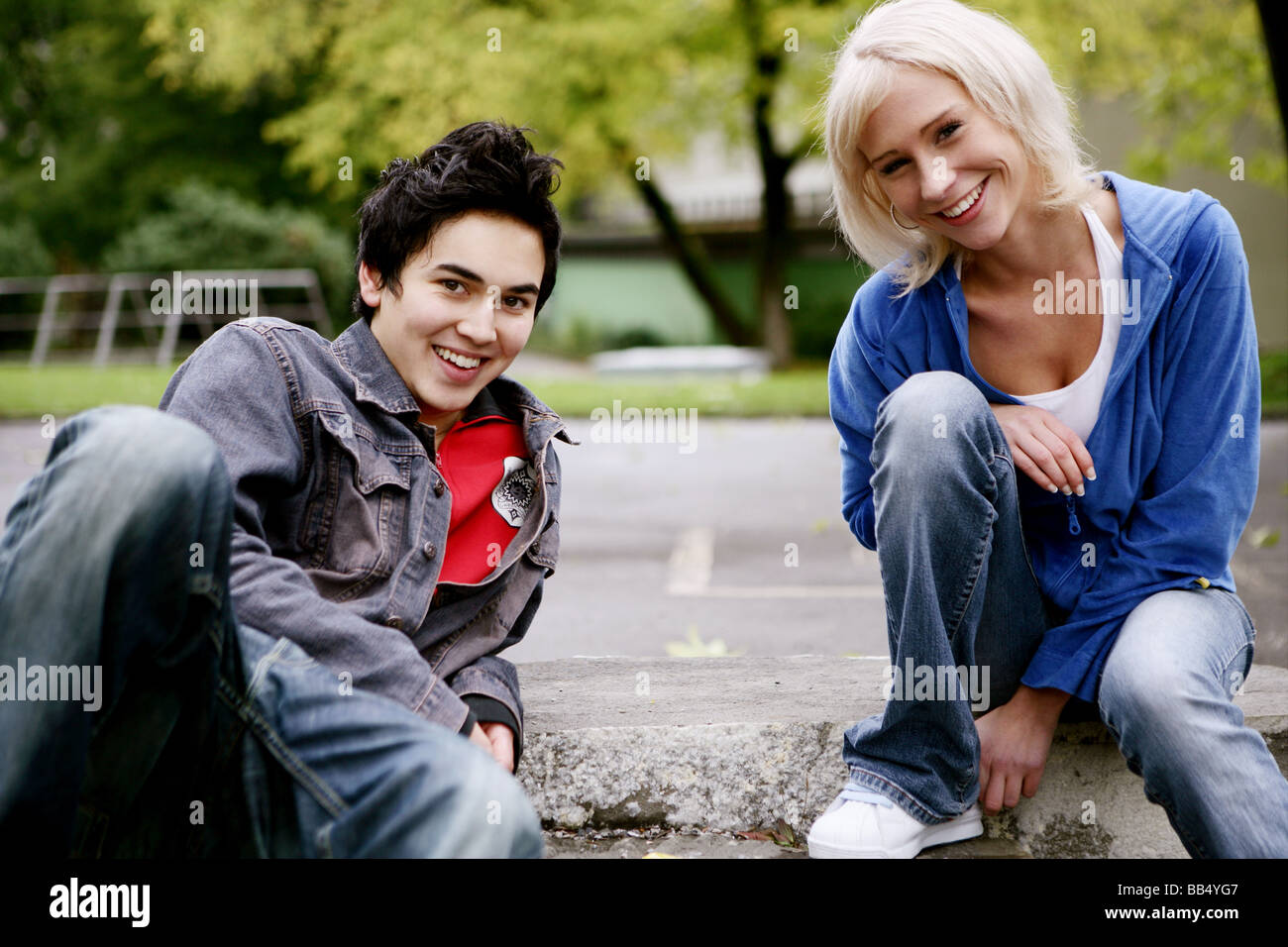 Teenager-Gruppe lächelnd sitzen im park Stockfoto