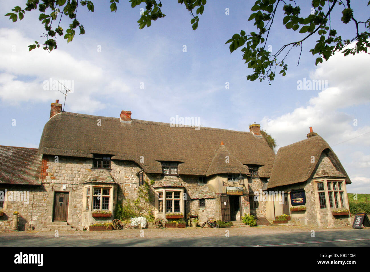 Wagen und Pferde Country-Pub mit traditionellen strohgedeckten Dach Beckhampton Marlborough Wiltshire England Stockfoto