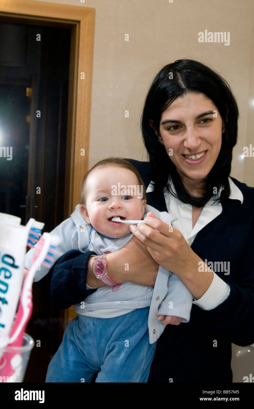 6 Monate altes Baby waschen seine Zähne mit seiner Mutter Stockfoto