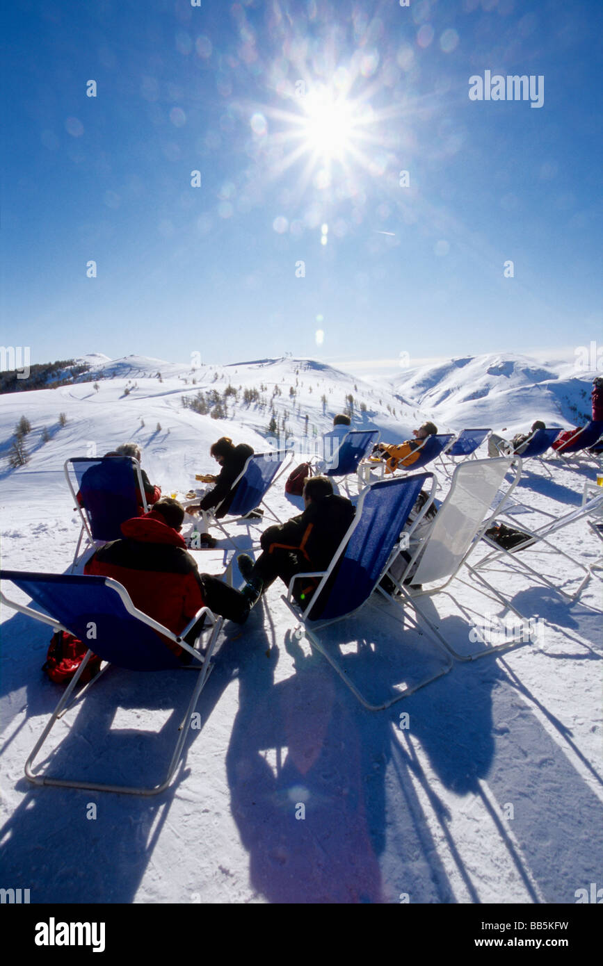 Menschen, die in der Top-Ski-Station von Valberg haben ein herrliches Panorama der schneebedeckten Gipfel vor ihnen entspannen Stockfoto